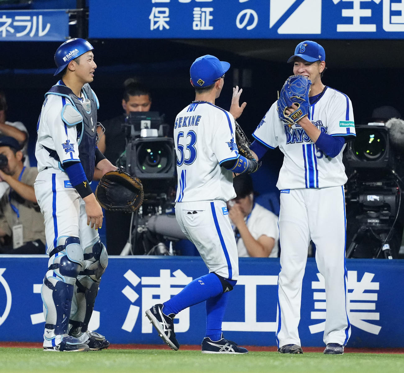 DeNA対ヤクルト　8回表終了後、DeNA左翼手関根（中央）と笑顔でタッチを交わす先発の平良。左は捕手山本（撮影・江口和貴）