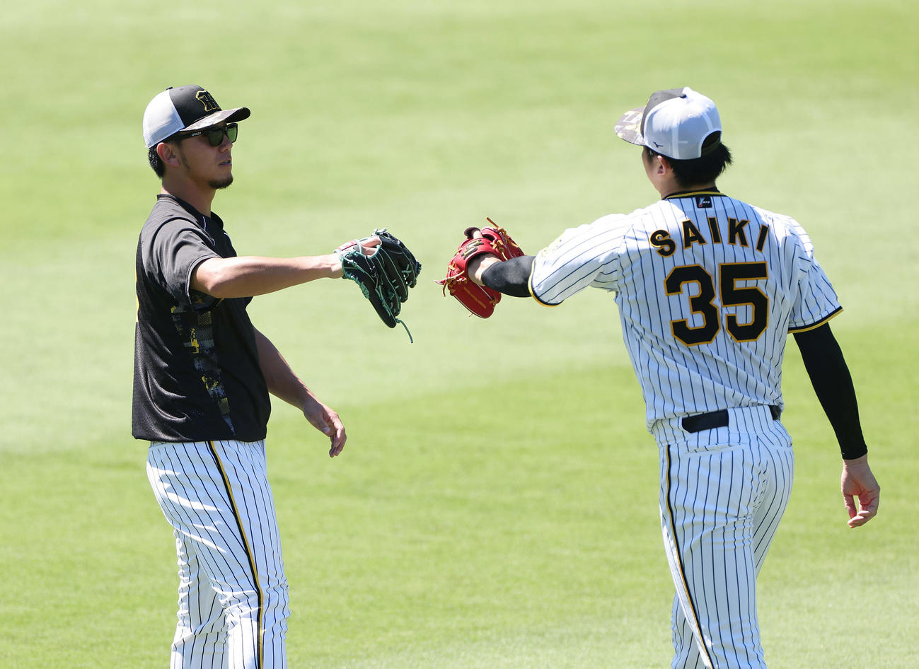 阪神対DeNA　キャッチボールを終えタッチを交わす阪神伊藤将（左）と才木（撮影・前田充）