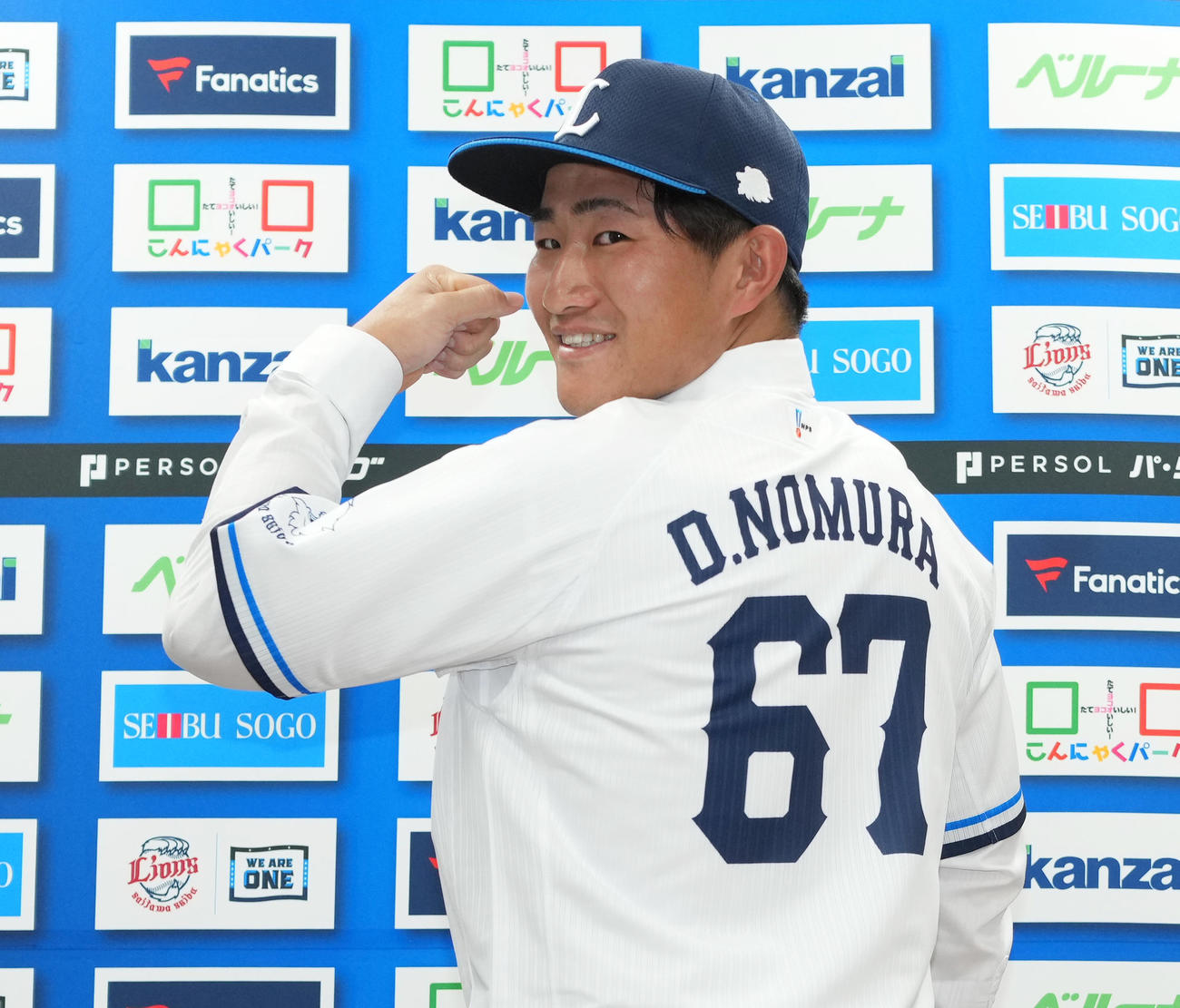 入団会見でユニホームに袖を通し、背番号を披露する西武野村大（撮影・菅敏）