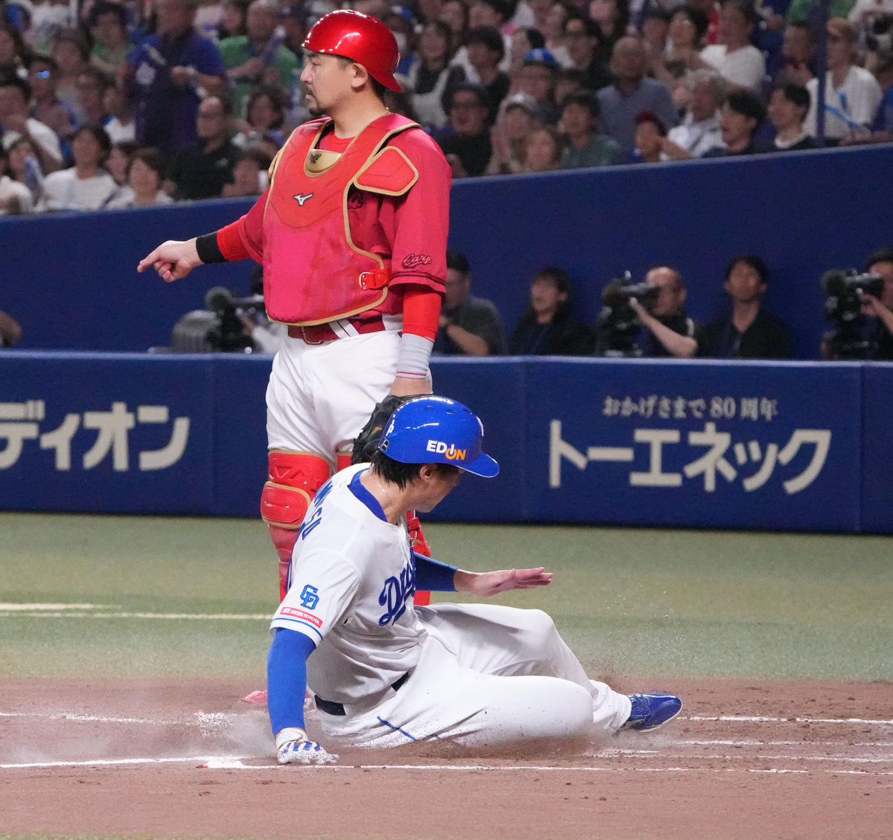 中日対広島　3回裏中日1死満塁、福永の右犠飛で生還する梅津（手前）捕手は会沢（撮影・森本幸一）