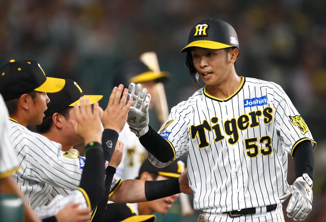 阪神対DeNA 5回裏阪神1死三塁、小幡の右前適時打で生還し、出迎えを受ける三走島田（右）（撮影・上山淳一）