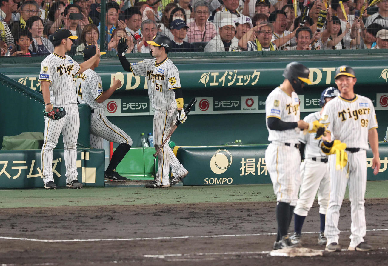 阪神対DeNA 6回裏阪神2死一、三塁、伊藤将（左）は佐藤輝の勝ち越し適時打で生還した中野とハイタッチ（撮影・宮崎幸一）