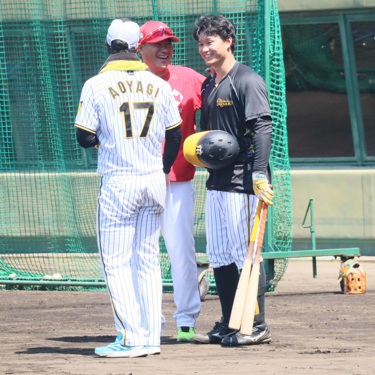 鳴尾浜で談笑する、日本生命特別コーチの福留氏（奥）と阪神森下、青柳（撮影・村松万里子）