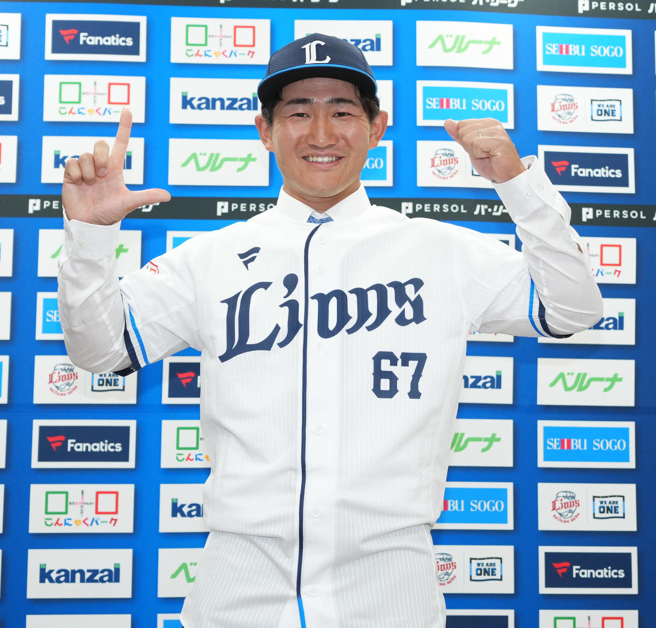 入団会見でユニホームに袖を通し、笑顔でポーズをとる西武野村大樹（2024年7月5日撮影）