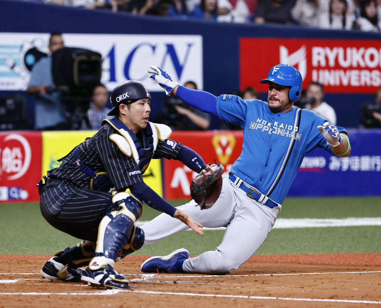 オリックス対日本ハム　5回表日本ハム1死一、三塁、五十幡（左）の投前スクイズでマルティネスが生還する。捕手若月（撮影・藤尾明華）