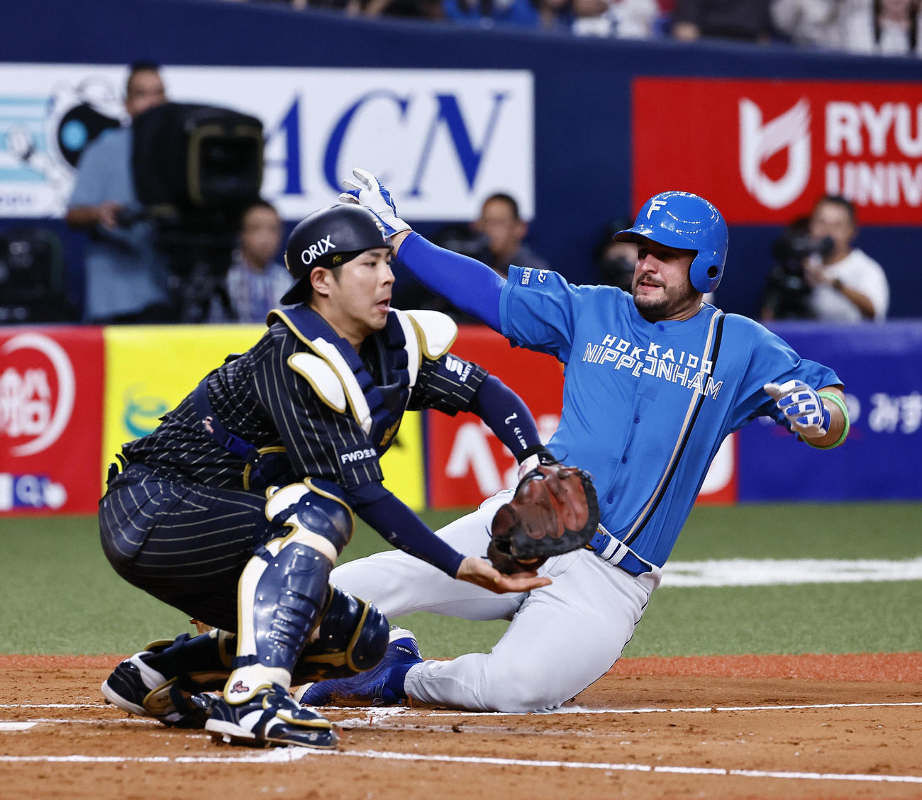 オリックス対日本ハム　5回表日本ハム1死一、三塁、五十幡（左）の投前スクイズでマルティネスが生還する。捕手若月（撮影・藤尾明華）
