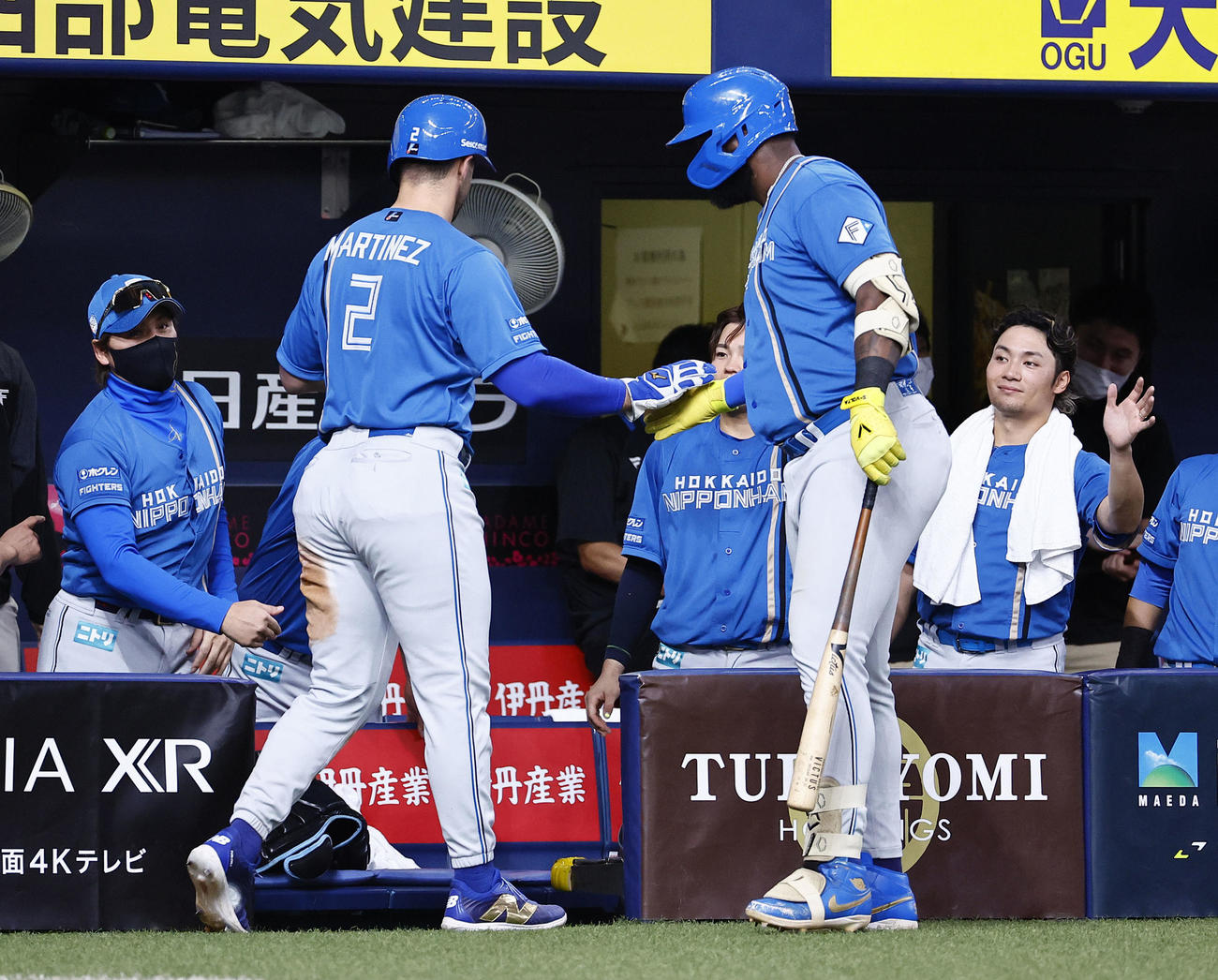 オリックス対日本ハム　5回表日本ハム1死一、三塁、五十幡の投前スクイズで生還したマルティネスを出迎える新庄監督（左端）と伊藤（右端）（撮影・藤尾明華）