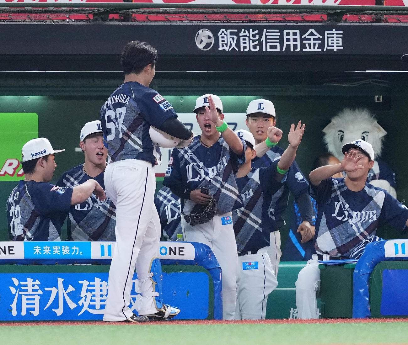 西武対ロッテ　5回裏西武1死一、三塁、左犠飛を放ち、ナインに迎えられる野村（左から3人目）（撮影・菅敏）