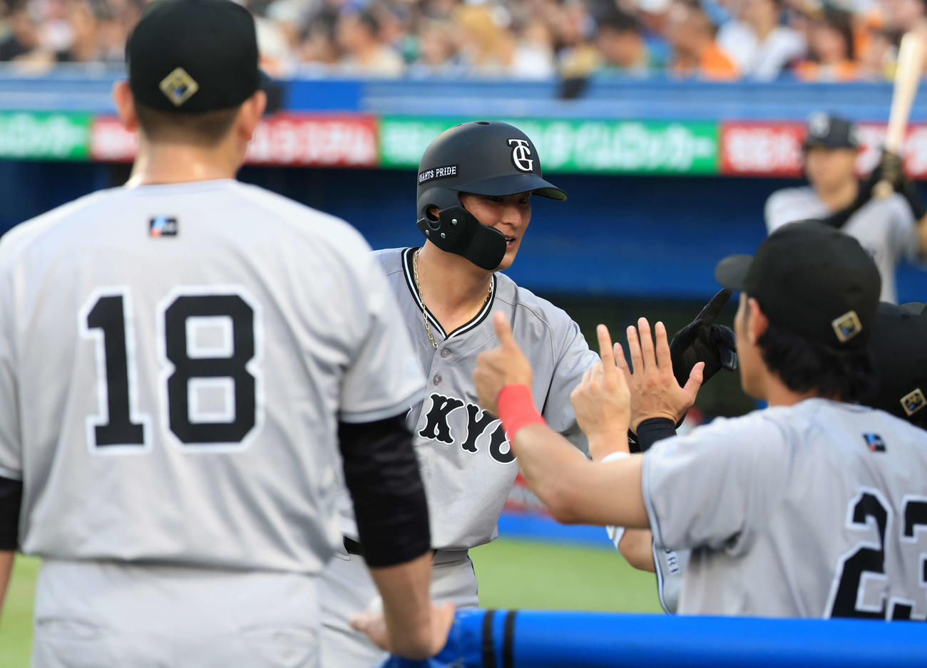 ヤクルト対巨人　2回表巨人2死二塁、岡本和の左適時二塁打で生還した吉川はナインと「1」のポーズでハイタッチ（撮影・浅見桂子）