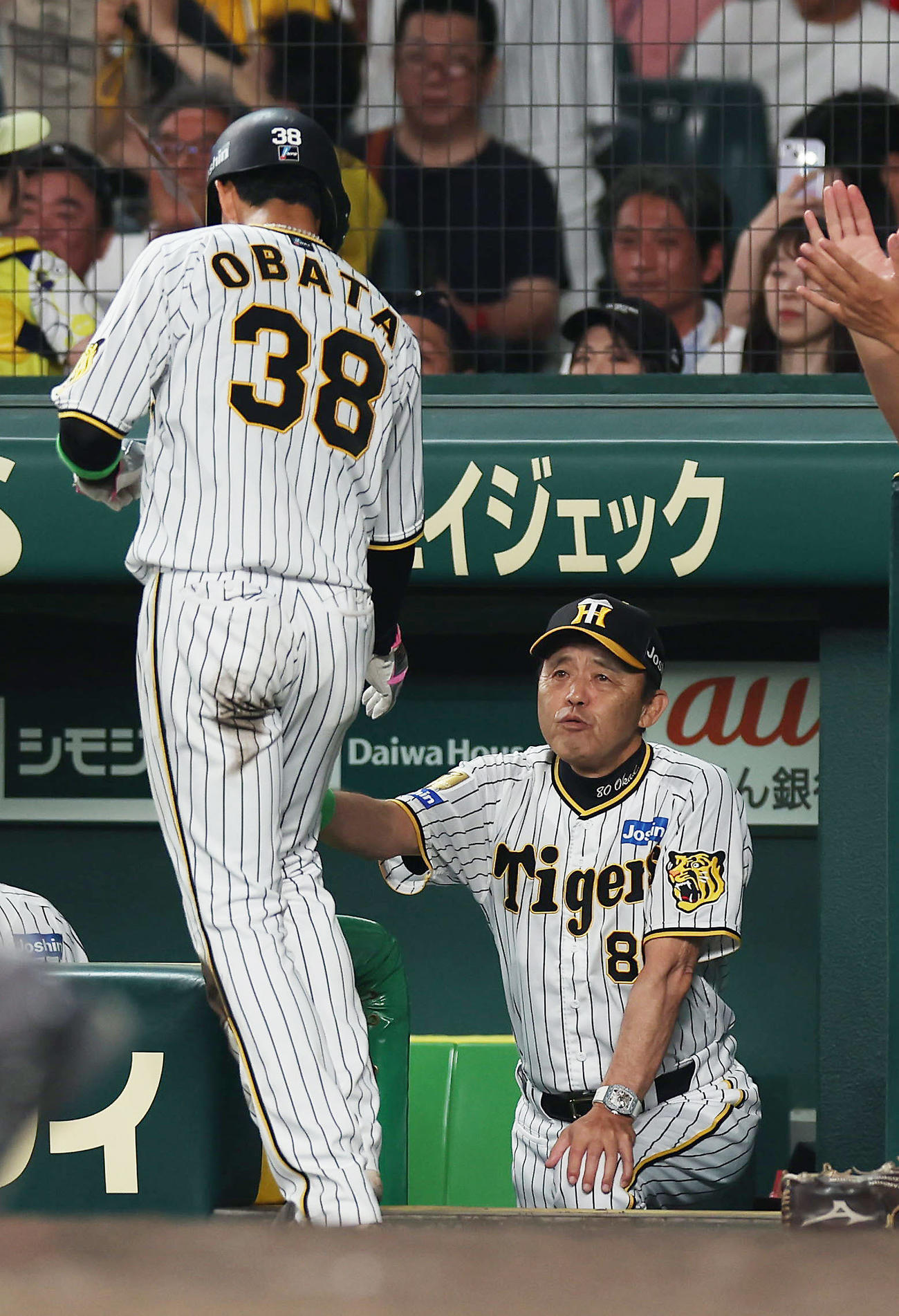 阪神対DeNA 5回裏阪神無死一塁、野口の右前打と失策で生還した小幡（左）を迎える岡田監督（撮影・前田充）