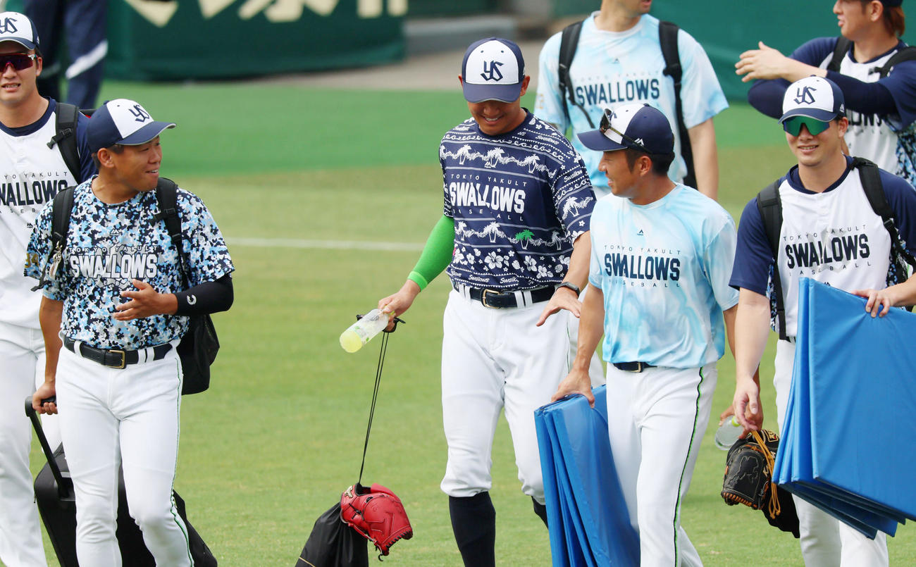 阪神対ヤクルト　田口（左）、嘉弥真（右）ら先輩が率先して荷物を運ぶため奥川は何かお手伝い…と手を伸ばす（撮影・加藤哉）