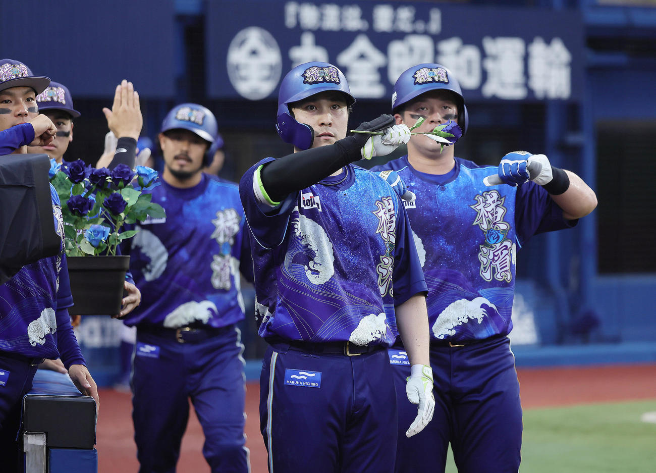 DeNA対中日　2回裏DeNA無死一、二塁、佐野（中央）は右越え3点本塁打を放ち青いバラを手にポーズを決める（撮影・足立雅史）