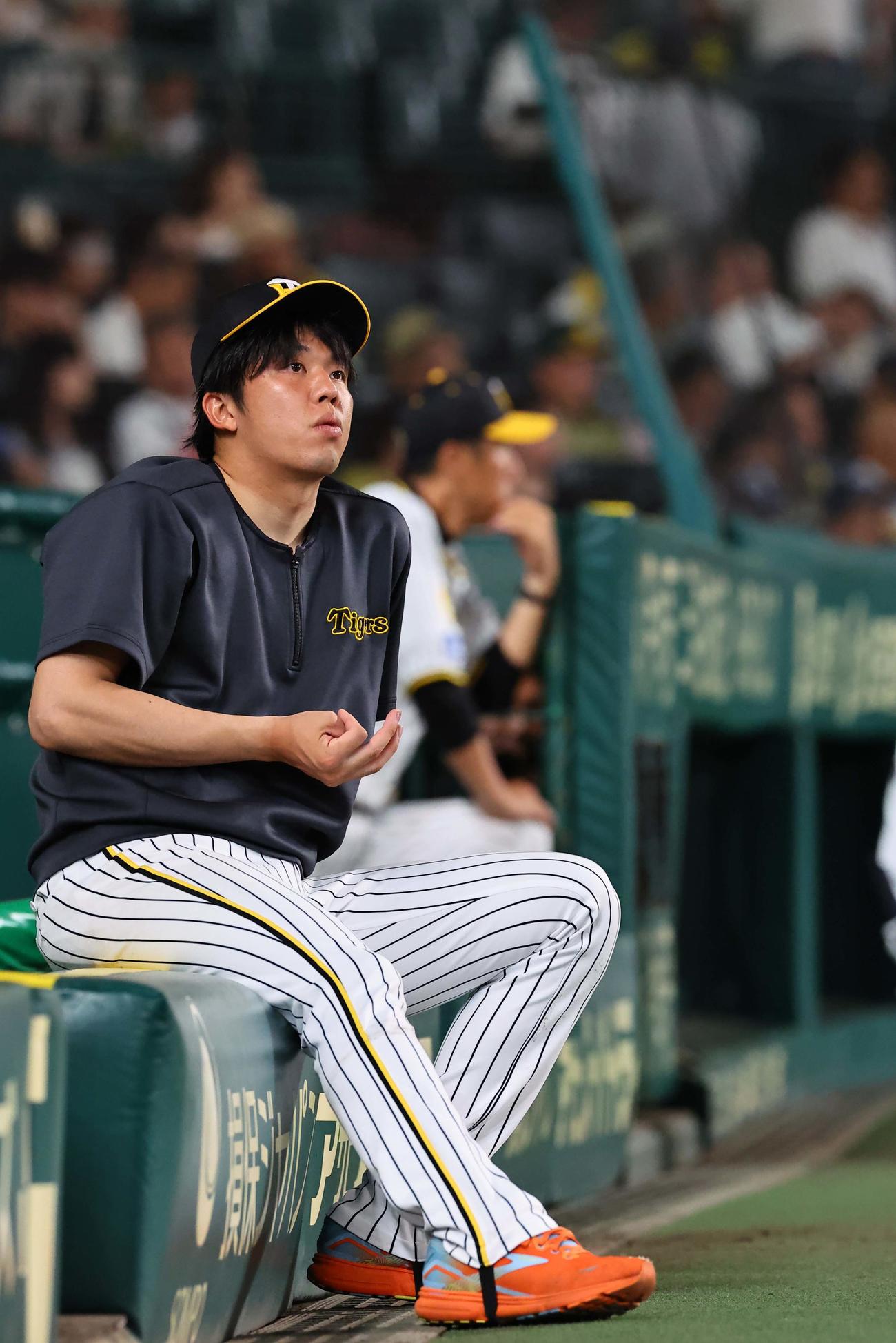 阪神対ヤクルト　ベンチのフェンスに座り指折り数える才木（撮影・上田博志）