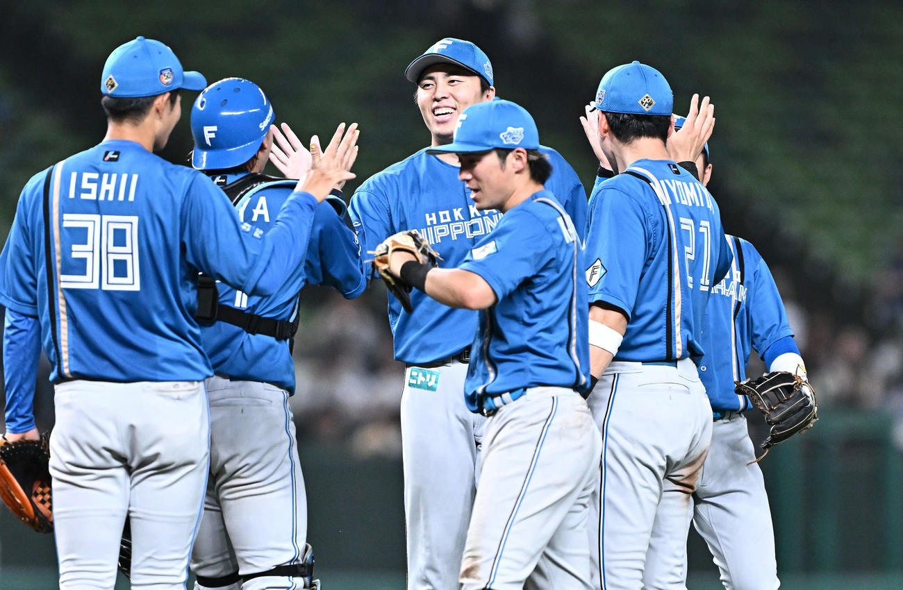 西武対日本ハム　10回裏、日本ハム5番手で登板し試合を締めた田中正（中央）はチームメートとタッチをかわす（撮影・滝沢徹郎）