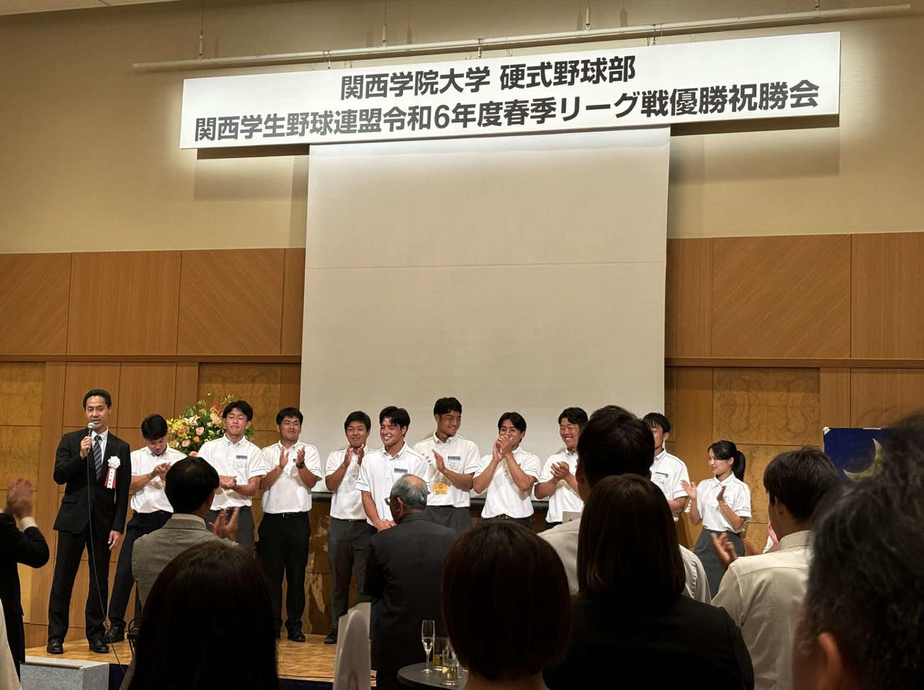 祝勝会の壇上で主力選手の紹介を行う関学大・本荘雅章監督（左）（撮影・古財稜明）