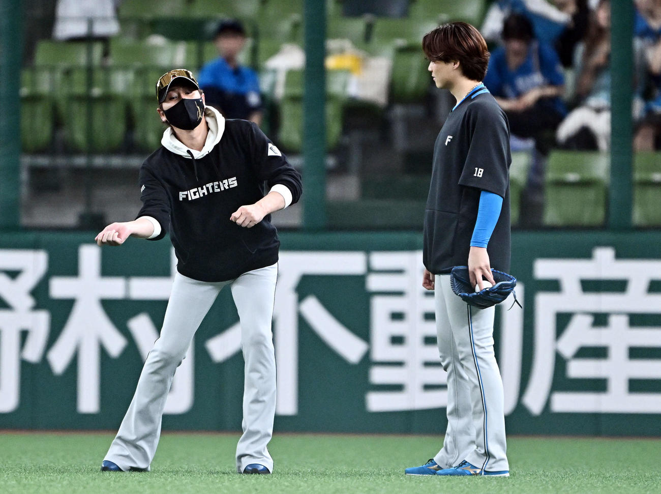 西武対日本ハム　試合前練習で話す日本ハム新庄監督（左）と山崎福（撮影・滝沢徹郎）