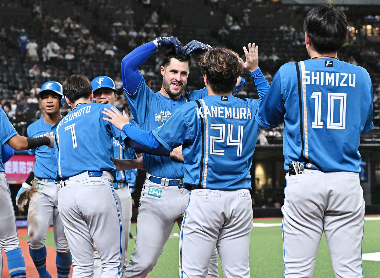 西武対日本ハム　8回表日本ハム1死一、二塁、左越え3点本塁打を放ったマルティネス（左から4人目）は生還しポーズを決める（撮影・滝沢徹郎）