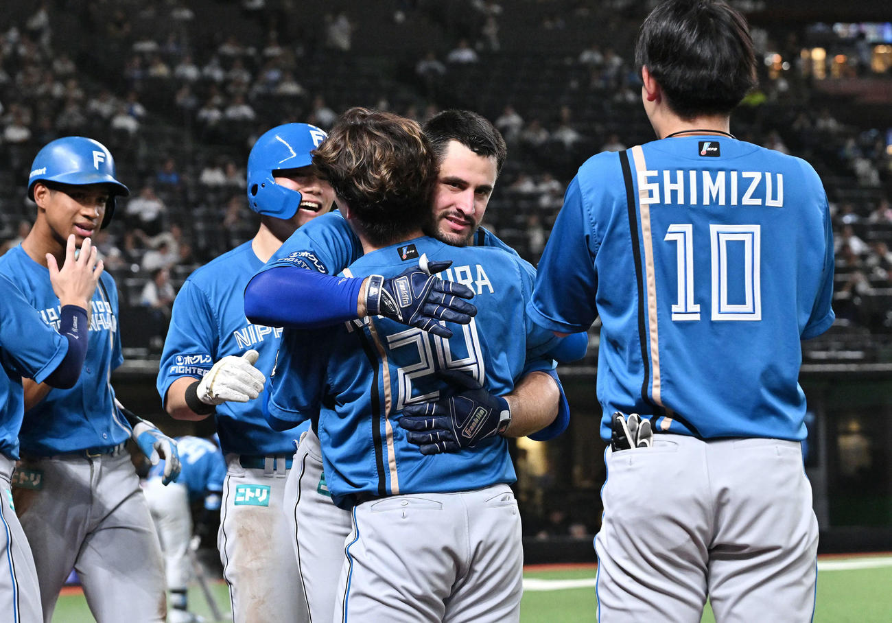 西武対日本ハム　8回表日本ハム1死一、二塁、左越え3点本塁打を放ったマルティネス（左から3人目）は生還し金村を抱き締める（撮影・滝沢徹郎）