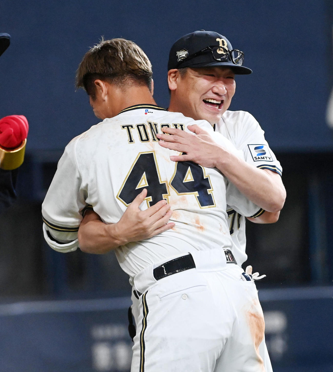 オリックス対ソフトバンク　9回、サヨナラ右犠飛を放った頓宮（背中）を笑顔で祝福する中嶋聡監督（撮影・前岡正明）