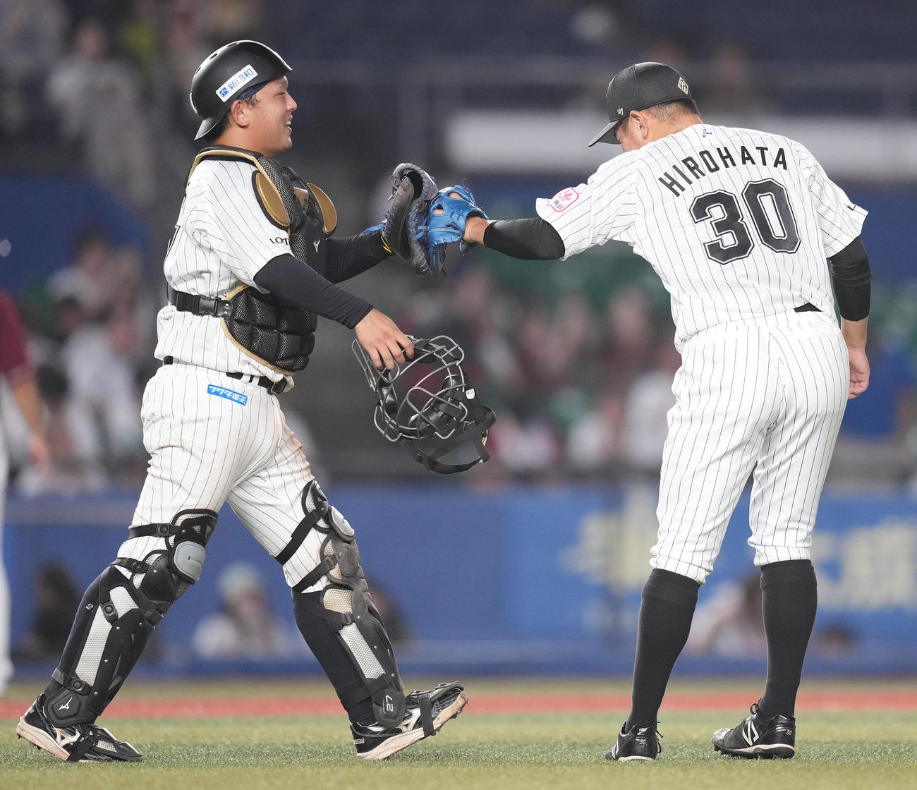 ロッテ対楽天　プロ初セーブのロッテ広畑（右）は田村とタッチを交わす（撮影・鈴木みどり）