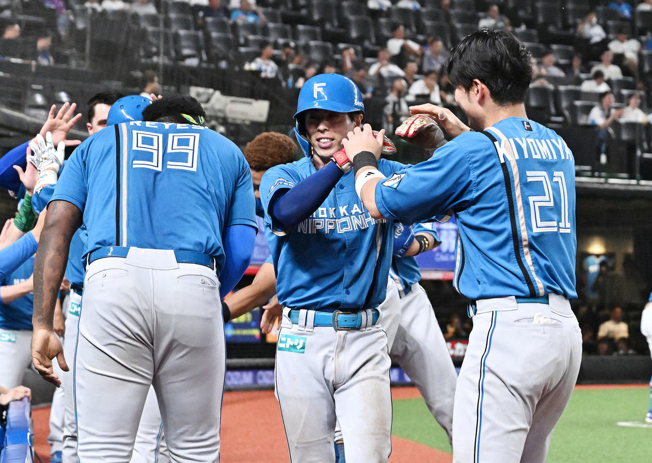 西武対日本ハム　7回表日本ハム1死三塁、代打郡司の中犠飛で生還した代走五十幡（中央）はチームメートとタッチをかわす（撮影・滝沢徹郎）