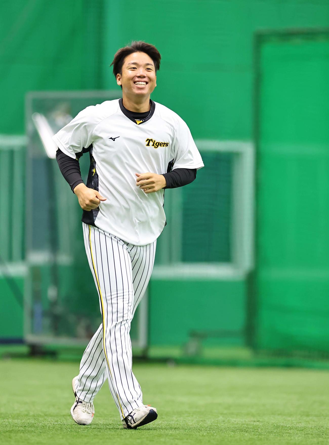 笑顔を見せながらウオーミングアップをする村上頌樹（撮影・上田博志）