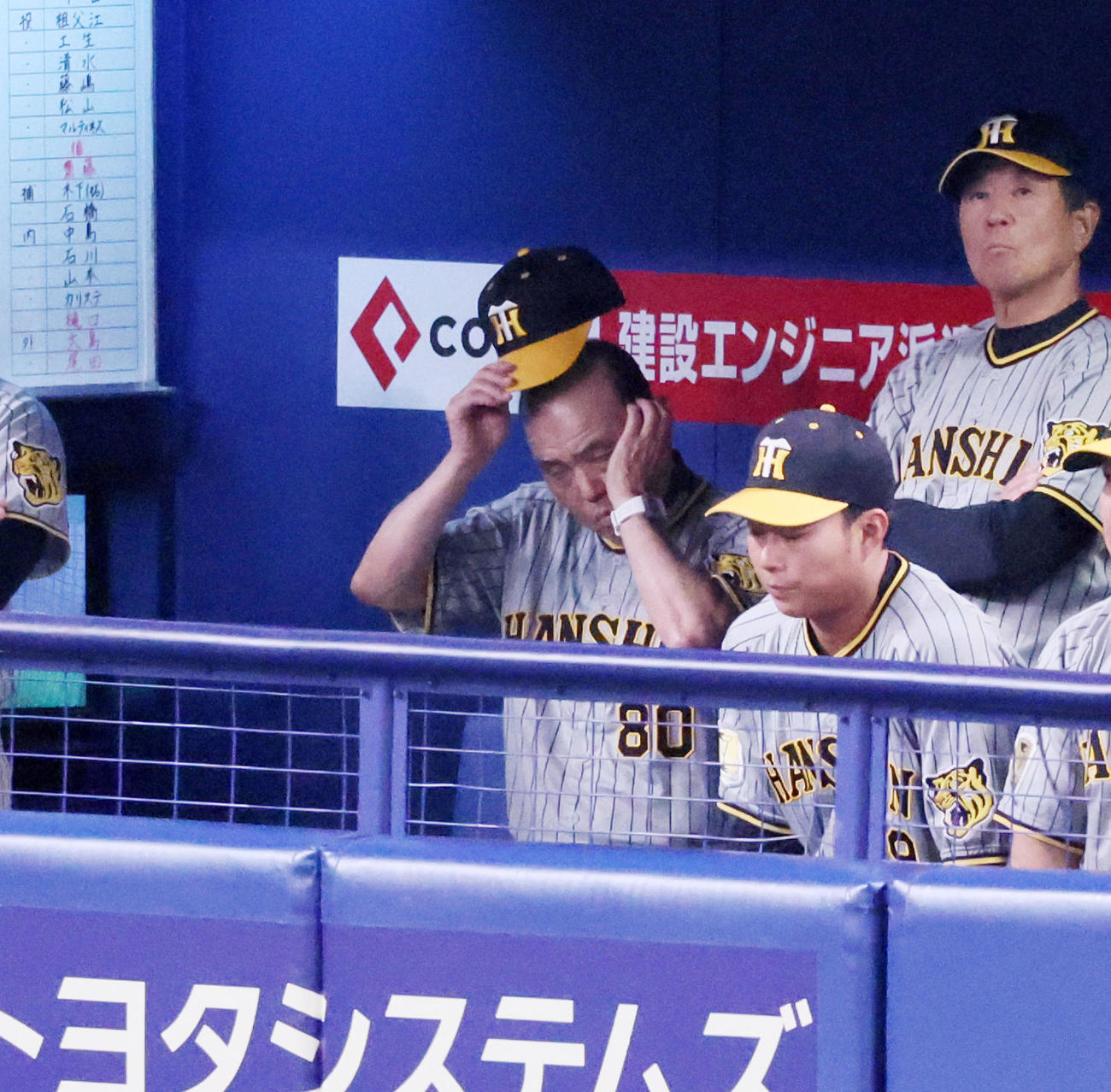 中日対阪神　3回裏、ベンチで帽子を取る岡田監督（撮影・加藤哉）