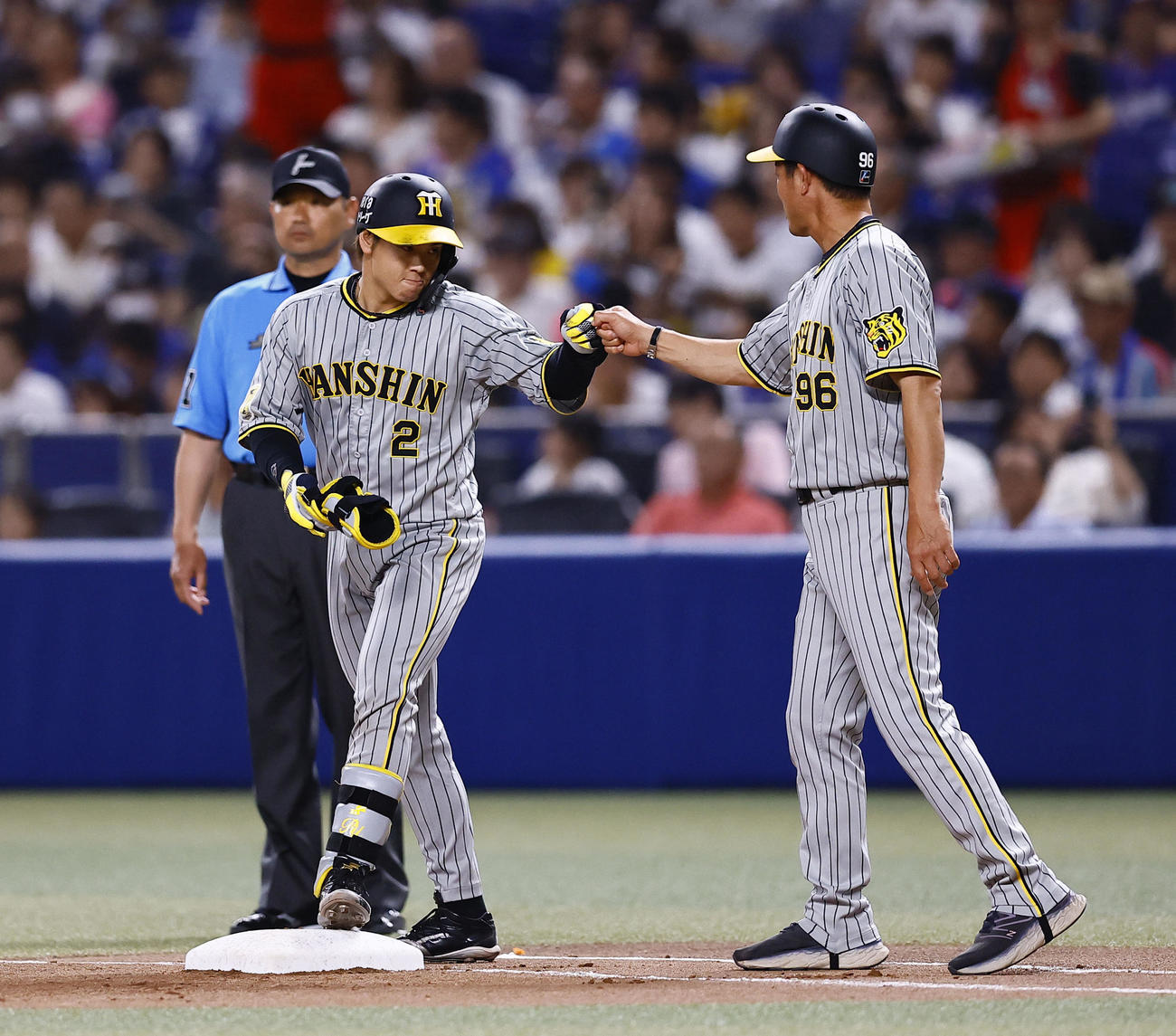 中日対阪神　8回表阪神1死、梅野は右前打を放ちタッチを交わす（撮影・藤尾明華）