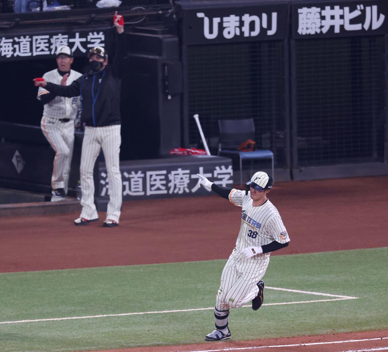 日本ハム対ソフトバンク　10回裏日本ハム1死、右中間に本塁打を放ちポーズをとる石井。新庄監督も歓喜する（撮影・黒川智章）