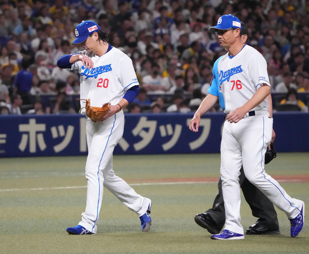 中日対阪神　2回表開始前、マウンド上で異変を訴えベンチへ戻る涌井（左）（撮影・森本幸一）