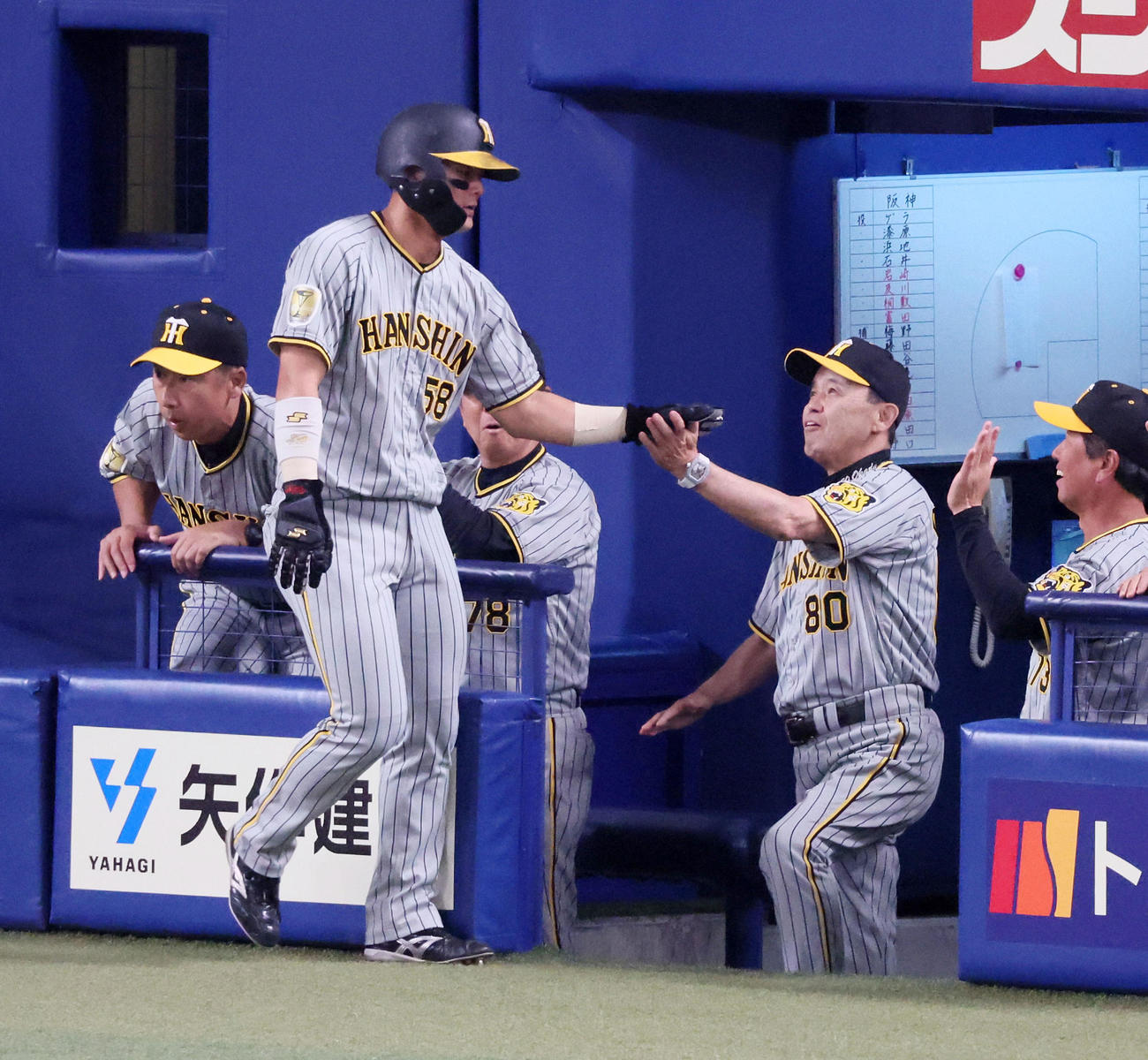 中日対阪神　2回表阪神無死二、三塁、大山の右適時2点二塁打で生還した二塁走者前川（左）はベンチの岡田監督とタッチ（撮影・加藤哉）