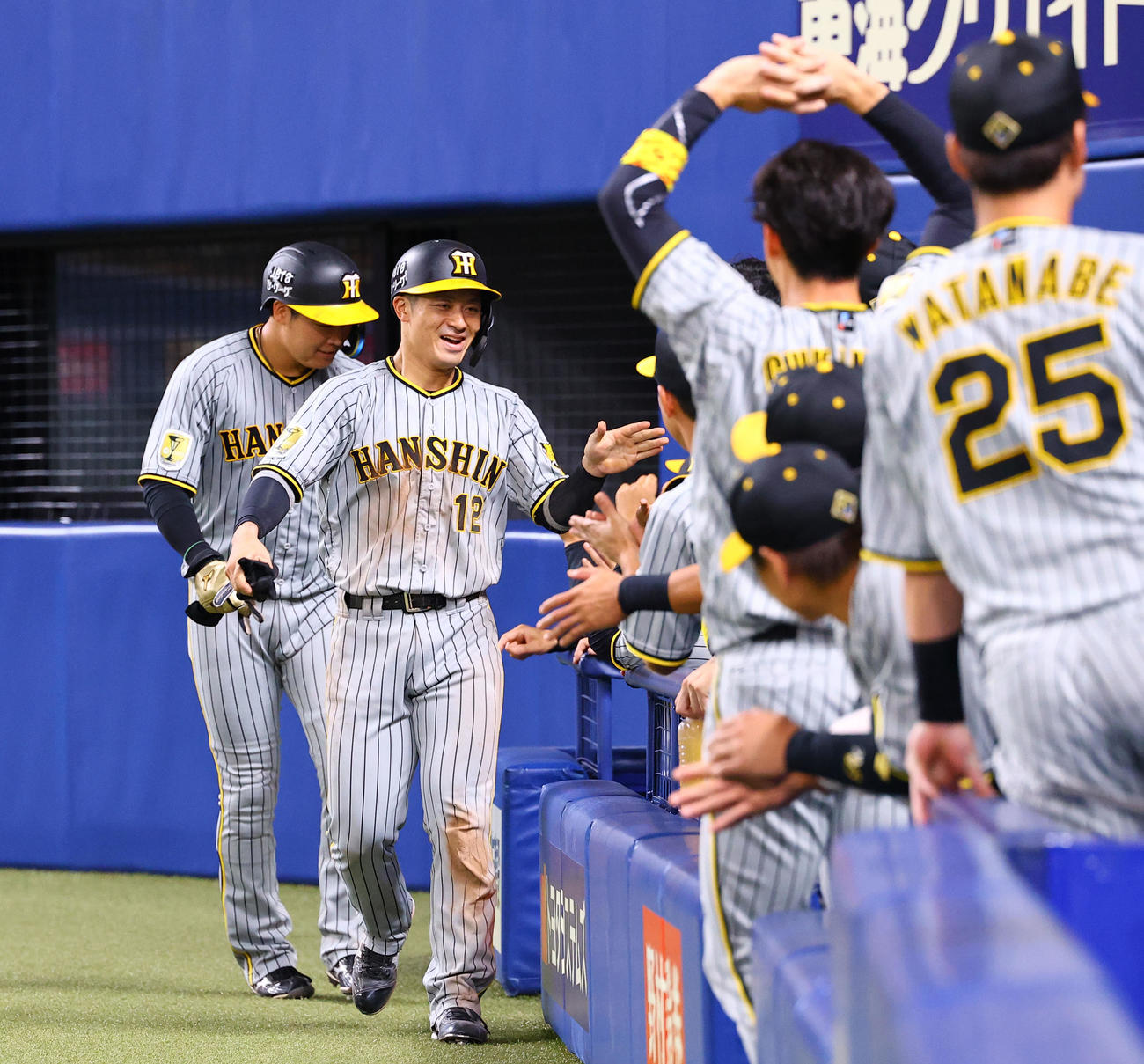 中日対阪神　5回表阪神2死一、三塁、小幡竜平の右越えに2点適時三塁打で生還し、ナインとタッチを交わす坂本（左から2人目）と大山（左端）（撮影・藤尾明華）