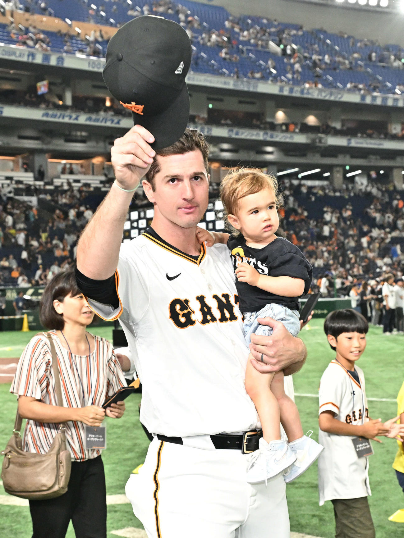 巨人対DeNA　試合後、愛娘を抱いてファンにあいさつする巨人グリフィン（撮影・滝沢徹郎）