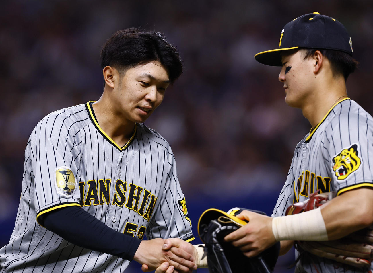中日対阪神　4回、同点打を放ち前川（右）と握手を交わす島田（撮影・藤尾明華）