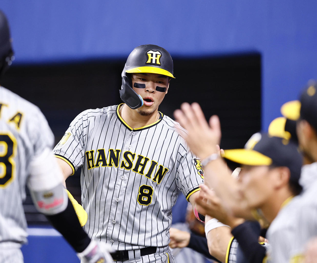中日対阪神　2回表阪神無死二、三塁、大山の2点適時二塁打で生還し、ナインとタッチを交わす佐藤輝（撮影・藤尾明華）
