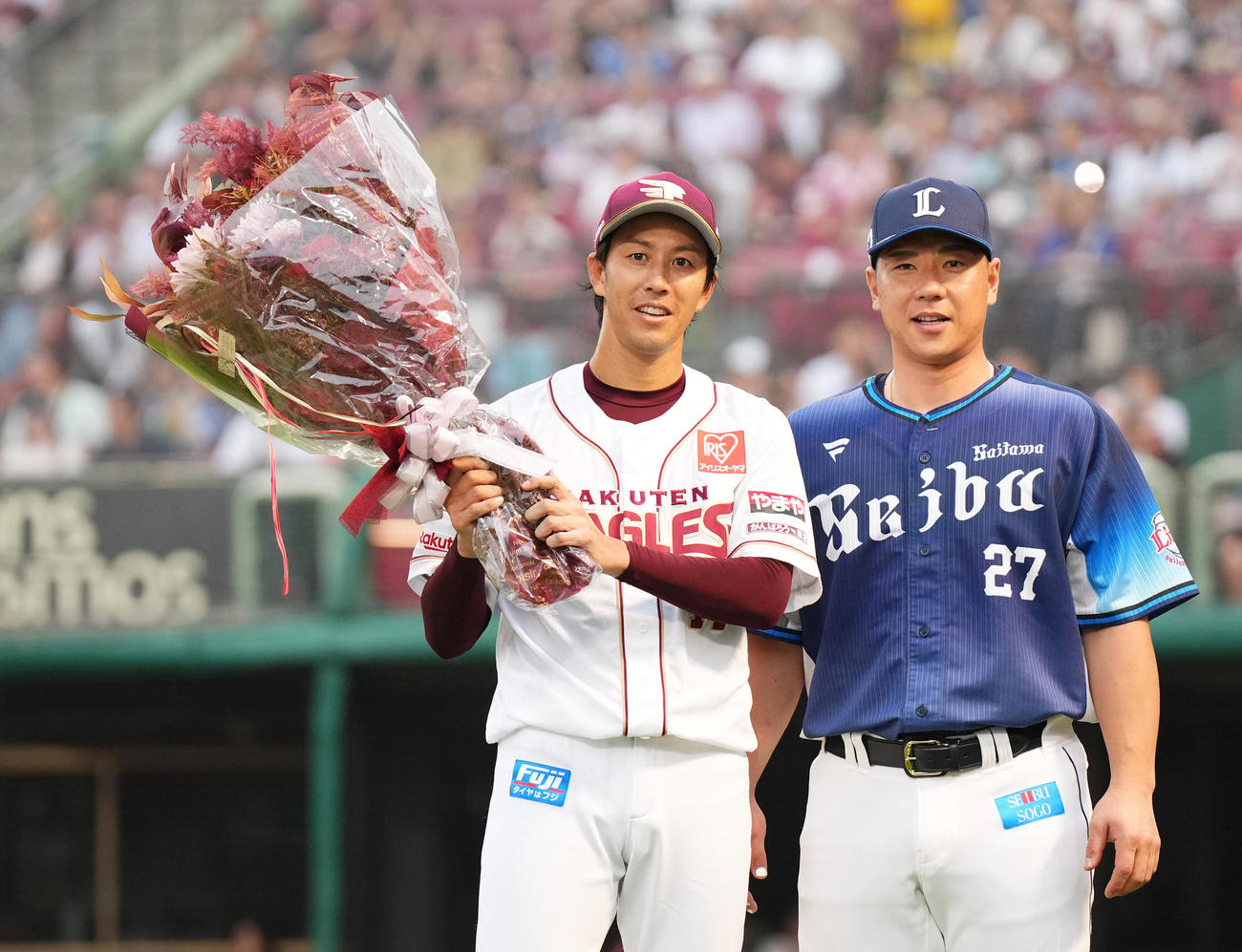 楽天対西武　6回を終え、通算2500回投球を達成し、西武炭谷（右）から受け取った花束を手に笑顔を見せる楽天岸（撮影・菅敏）