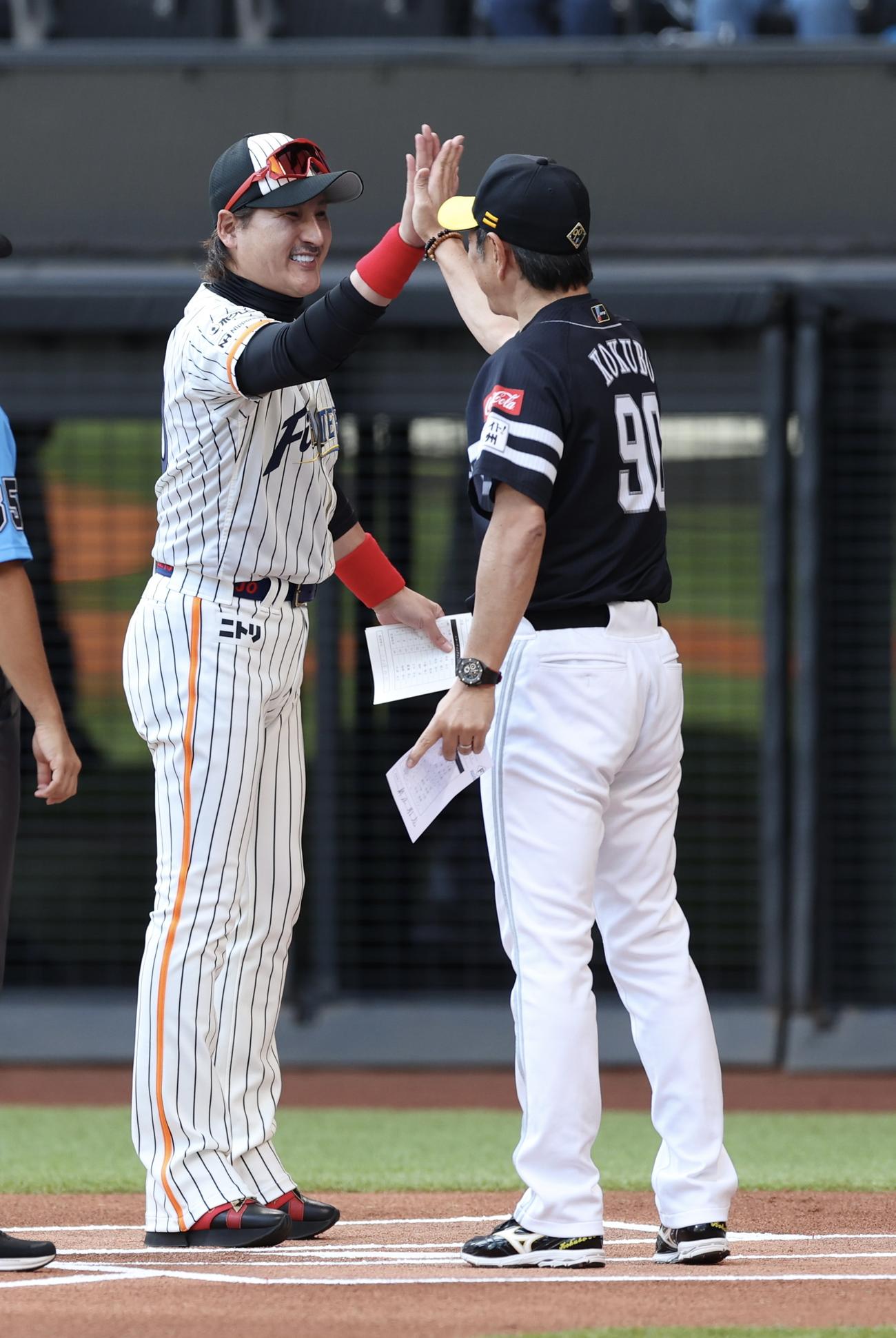 日本ハム対ソフトバンク　試合前、ハイタッチをする日本ハム新庄監督（左）とソフトバンク小久保監督（撮影・佐藤翔太）