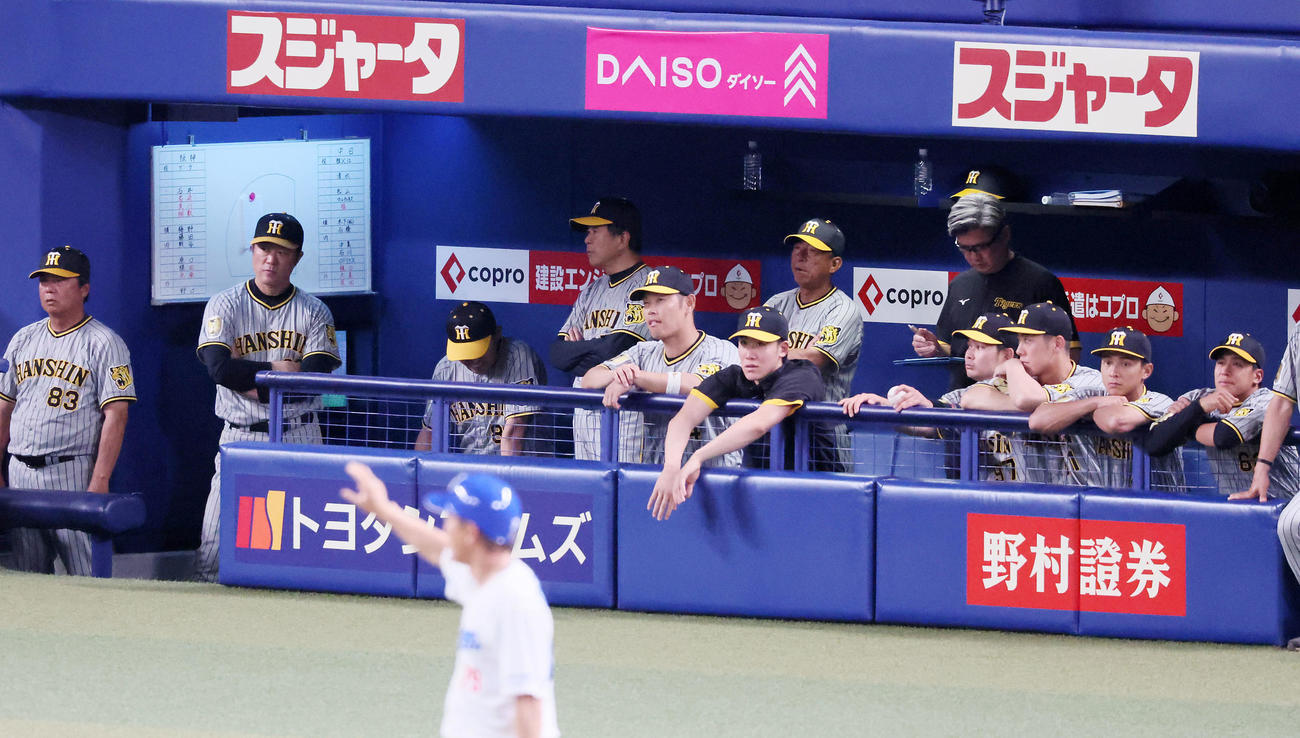 中日対阪神　5回裏中日2死二塁、藤嶋に右適時打を打たれベンチでうなだれる岡田監督（左から3人目）とグラウンドを見つめるナイン（撮影・加藤哉）