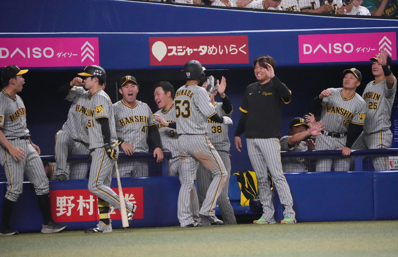 中日対阪神　10回表阪神1死一、二塁、原口の左前適時打で生還した島田を迎える阪神ナイン（撮影・森本幸一）
