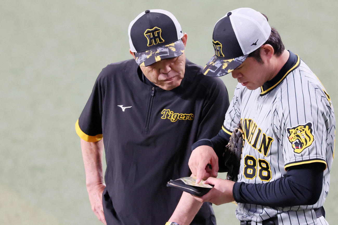 中日対阪神　安藤コーチ（右）と日程表を見ながら話す岡田監督（撮影・加藤哉）
