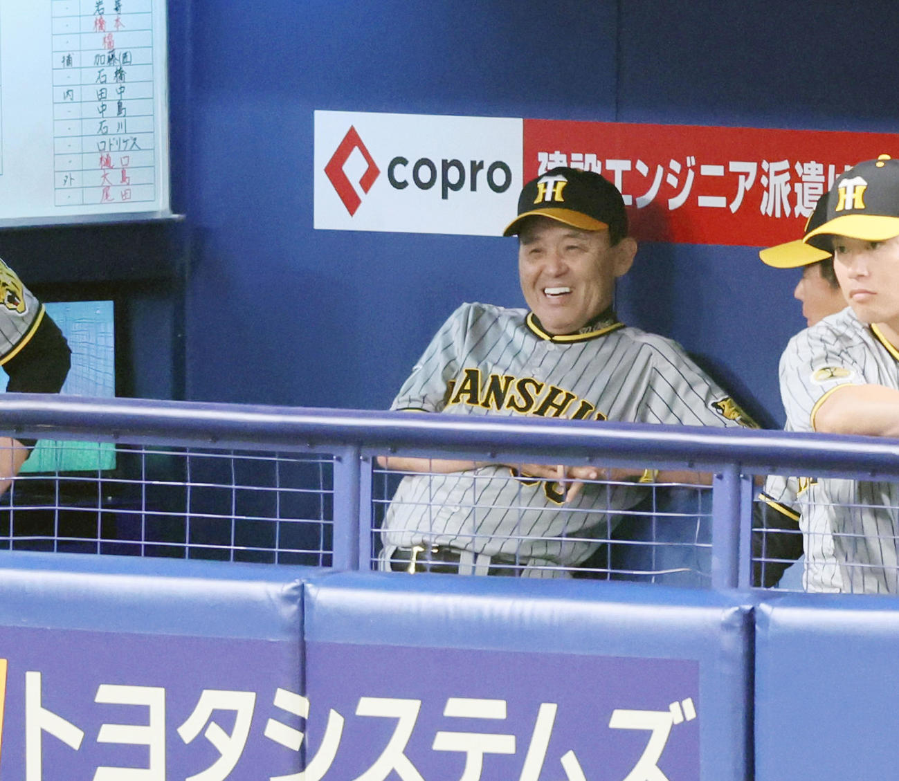 中日対阪神　1回表を終えベンチで笑顔を見せる岡田監督（撮影・加藤哉）