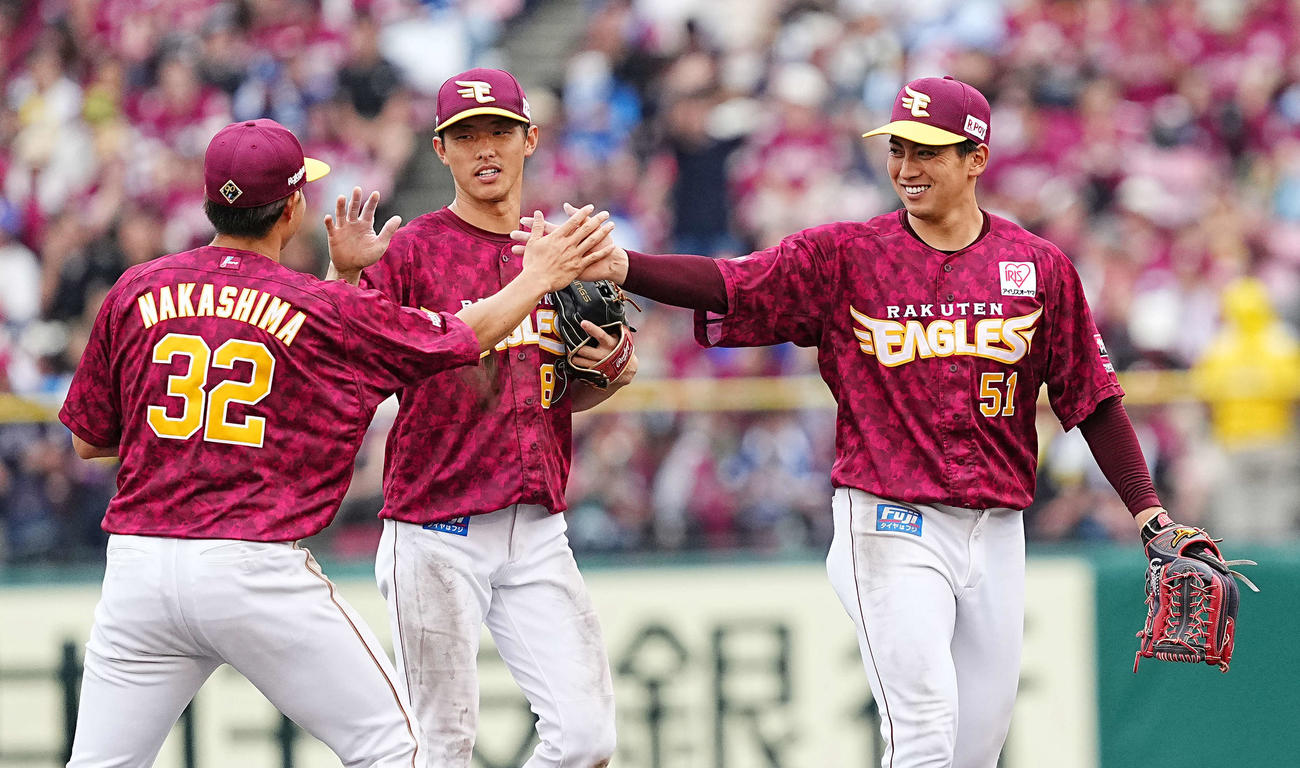 楽天対西武　西武に勝利し、中島（左）といタッチをする小郷。中央は辰己（撮影・菅敏）