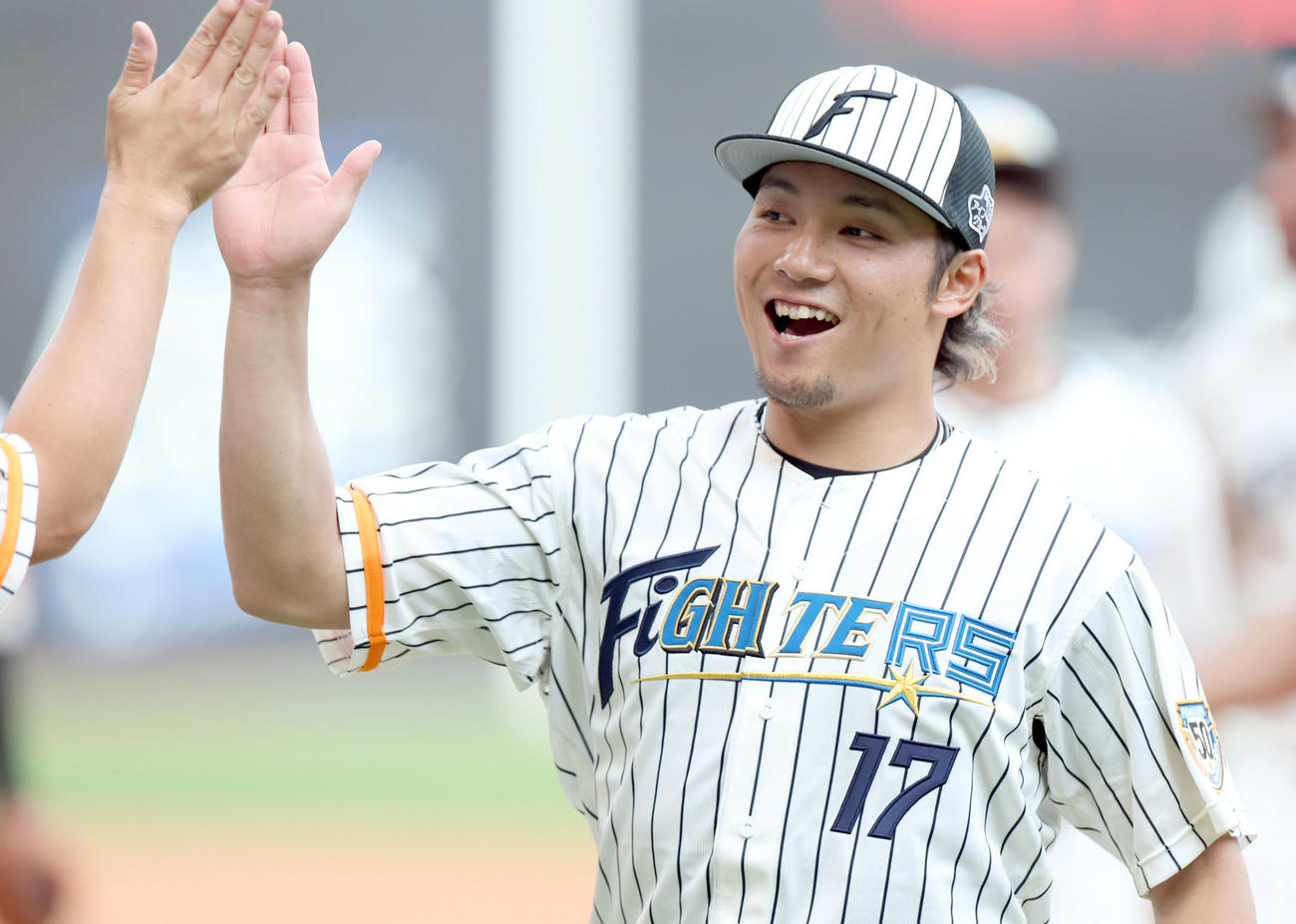 日本ハム対ソフトバンク　試合終了後、ナインと笑顔でハイタッチをする日本ハム伊藤（撮影・佐藤翔太）