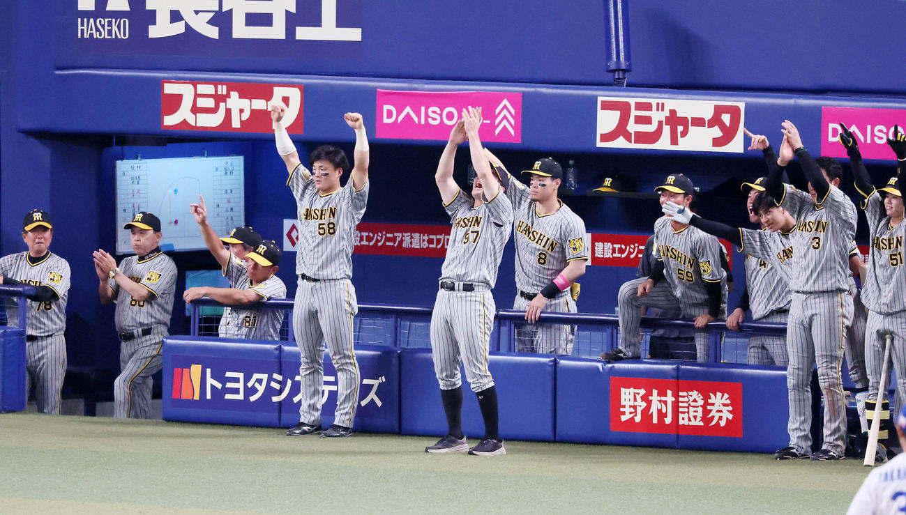 中日対阪神　10回表阪神1死一、二塁、代打原口の左適時打に喜ぶベンチのナインと拍手する左から2人目の岡田監督（撮影・加藤哉）