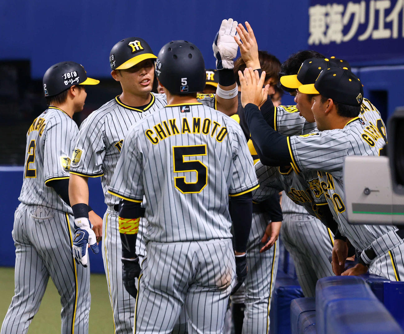 中日対阪神　10回表阪神2死満塁、植田の走者一掃の三塁打で生還し、ナインとタッチを交わす原口（左から2人目）（撮影・藤尾明華）