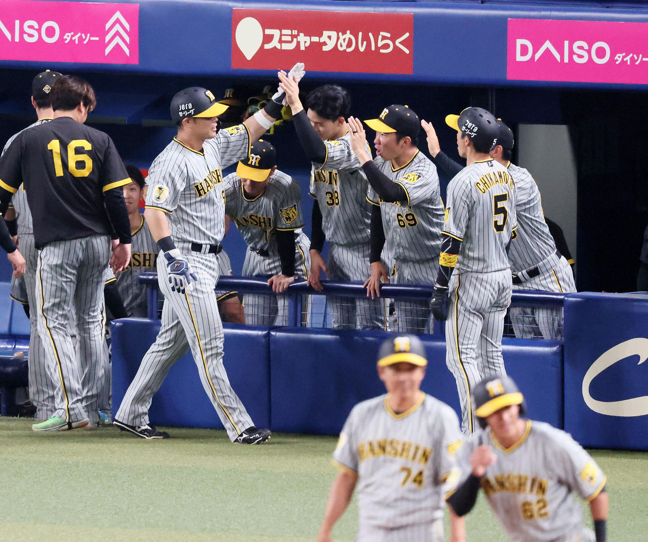 中日対阪神　10回表阪神2死満塁、植田の中適時3点三塁打で生還しベンチのナインとタッチする原口（撮影・加藤哉）