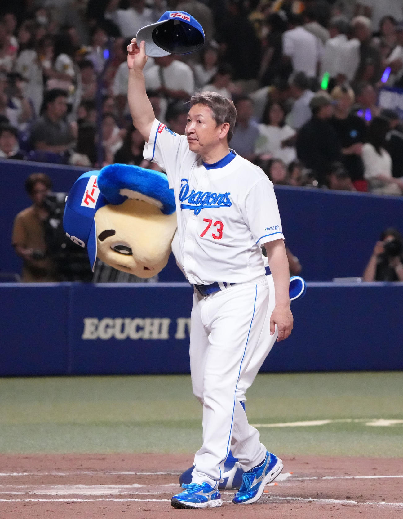 12日、スタンドの観客に手を振る立浪監督とおじぎするドアラ（奥）
