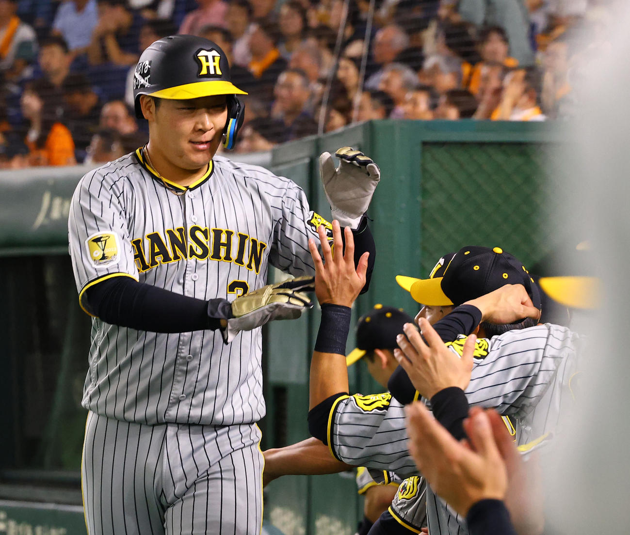巨人対阪神　4回に左越え2点適時三塁打を放ちナインとタッチを交わす阪神大山（撮影・藤尾明華）