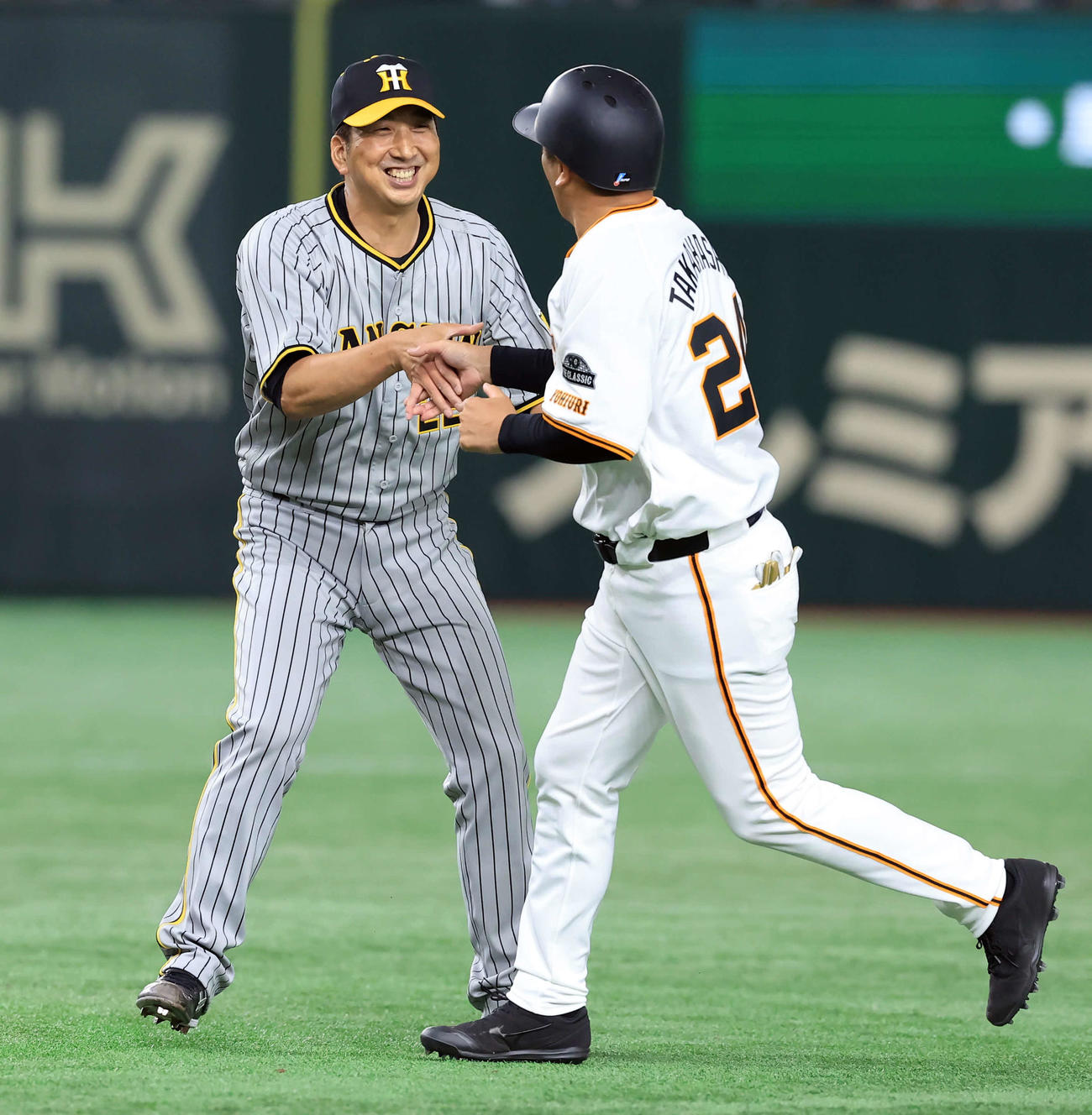 OB戦　巨人対阪神　5回裏巨人の攻撃で高橋由伸氏（手前）を打ち取り、笑顔の藤川球児氏（撮影・浅見桂子）