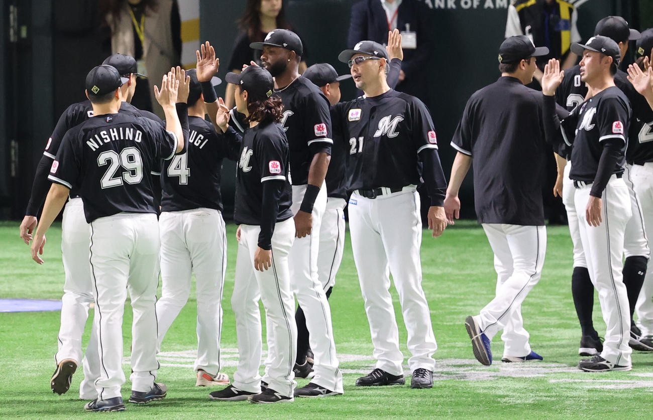ソフトバンク対ロッテ　ソフトバンクに勝利しタッチを交わすロッテナインと吉井監督（中央）（撮影・鬼束羽瑠菜）